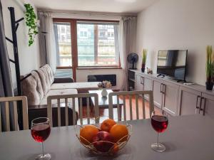 einen Tisch mit einer Schale Obst und zwei Gläsern Wein in der Unterkunft Deluxe Apartment In Belvedere With Terrace in Bansko