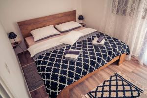 a bedroom with a bed with a black and white comforter at Kuća za odmor Grđan in Slatinski Drenovac +53 photos