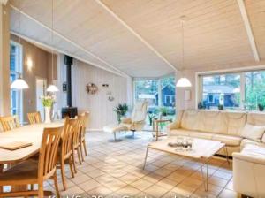 a living room with a couch and a table at Summerhouse On The Beach And With Ocean View in Yderby +15 photos