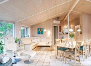 a living room with a couch and a table and chairs at Summerhouse On The Beach And With Ocean View in Yderby