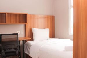 una camera da letto con un letto, una scrivania e un letto sidx sidx sidx di Fancy and Comfy 2BR Apartment at Springlake Summarecon By Travelio a Bekasi Altre 20 foto