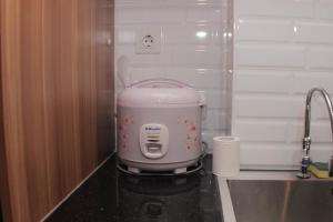 un robot da cucina seduto su un bancone in cucina di Fancy and Comfy 2BR Apartment at Springlake Summarecon By Travelio a Bekasi