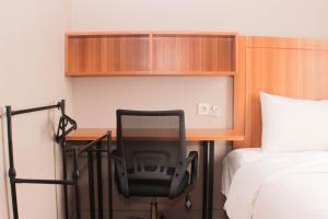 una scrivania in una stanza d'albergo con una sedia accanto al letto di Fancy and Comfy 2BR Apartment at Springlake Summarecon By Travelio a Bekasi