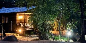 a log cabin with two lights in front of it at River Rock Lodge in Parys