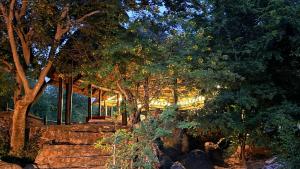 a building in the background with trees in the foreground at River Rock Lodge in Parys