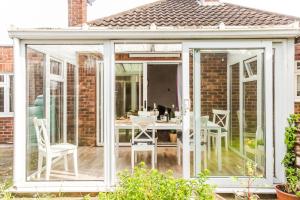 an extension of a conservatory with a table and chairs at Entire 4-Bedroom Home Surrey in Sunbury Common
