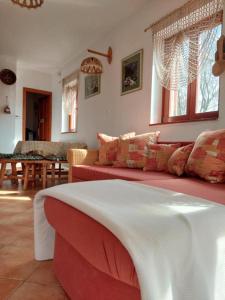 Una sala de estar con un sofá rojo y una mesa. en Hegy és Balaton Vendégház, en Badacsonytördemic