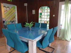 a dining room with a table and blue chairs at Le Salazia in Salazie