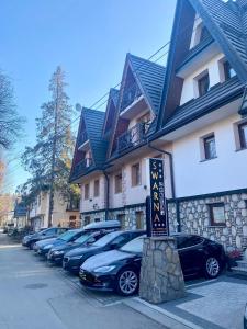 rząd samochodów zaparkowanych przed budynkiem w obiekcie Śwarna Wynajem Pokoi w Zakopanem
