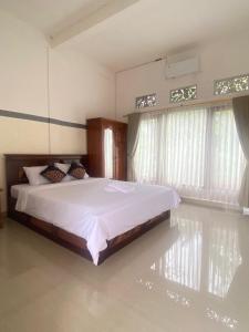 Ένα ή περισσότερα κρεβάτια σε δωμάτιο στο Sri Sedana Guest House