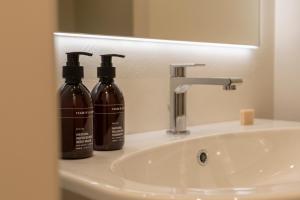 a bathroom sink with two bottles of soap at Domus Santa Croce in Bergamo +24 photos
