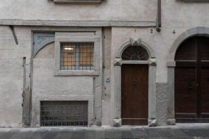 a building with two windows and a wooden door at Domus Santa Croce in Bergamo