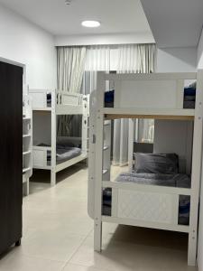 a room with three bunk beds in a room at Dubai Airport Hostel in Dubai