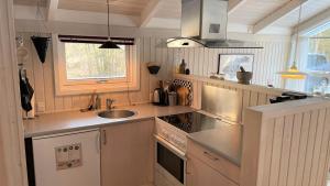 a kitchen with a sink and a stove top oven at Flot feriehus på Læsø - tæt på strand, natur og Vesterø Havn in Vesterø Havn