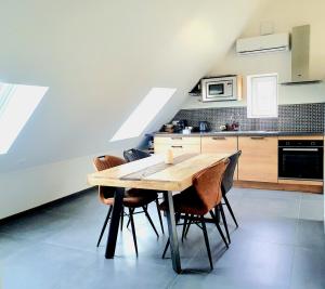 a kitchen with a wooden table and chairs at La Maison Blanche 74 Annecy-le-Vieux in Annecy