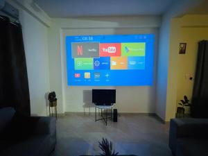 una gran pantalla en la sala de estar con TV en Netflix & Chill Projector Penthouse in Kondapur, en Kondapur