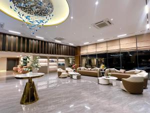 a lobby with couches and tables and a chandelier at Miloft Suvarnabhumi Airport Hotel in Lat Krabang
