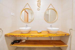 ein Badezimmer mit zwei Waschbecken und zwei Spiegeln in der Unterkunft Kizi Lovely apartment in Poço Partido + 35 Fotos