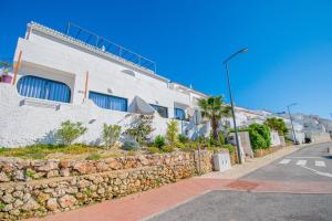 ein Gebäude mit einer Steinmauer neben einer Straße in der Unterkunft Kizi Lovely apartment in Poço Partido