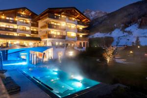 a building with a pool in front of it at night at Hotel Stubaierhof in Neustift im Stubaital