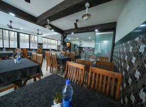 a restaurant with tables and chairs and a bottle of water at Kay Pee's Grande in Cochin