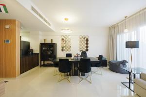 a living room with a dining room table and chairs at Modern Villa Stay Private & Secure Damac Hills 2 in Dubai