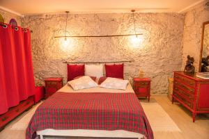 a bedroom with a bed with red curtains and two dressers at Quinta da Quinta in Vieira do Minho