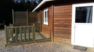 a wooden building with a gate and a door at L'Agrion Bleu in Saint-Martial-de-Valette +1 photo