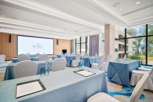 sala konferencyjna ze stołami, krzesłami i ekranem w obiekcie Kora Beach Resort Phuket w mieście Bang Tao Beach