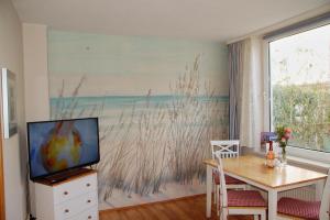 a living room with a television and a dining room table at CBlue "Friedrich Franz", 500 m zum Strand, zentral in Warnemünde