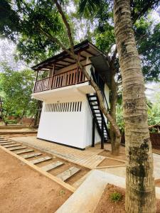 a small house with a tree in the foreground at Sigiri Inn in Kibissa +3 photos