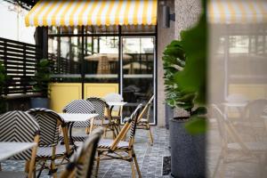 un groupe de chaises et de tables sur une terrasse dans l'établissement Forum Park Hotel, à Bangkok