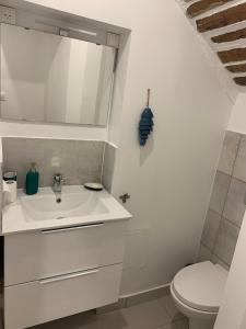 Un baño con un lavabo blanco y un inodoro. en Charming Old Town Appartment with AC and Parking, en La Ciotat 5 fotos más