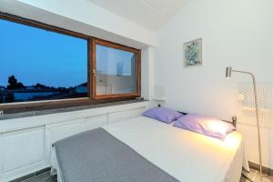 a bedroom with a bed and a large window at Boba lovely apartment close to Zrce beach in Gajac