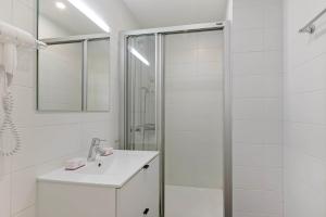 a white bathroom with a shower and a sink at Novos Contrada in Lugano