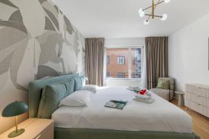 a bedroom with a bed and a chair and a window at Novos Contrada in Lugano