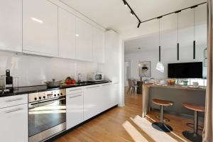 a white kitchen with white cabinets and a kitchen island at Novos Contrada in Lugano