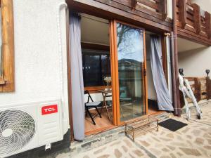 Zimmer mit Glasschiebetüren und einem Tisch in der Unterkunft Deluxe Apartment In Belvedere With Terrace in Bansko + 24 Fotos