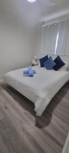 a bed with blue pillows on it in a room at 2 x Bedroom Deluxe Hampton Apartment in Shoal Bay