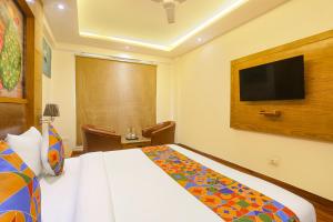 a hotel room with a bed and a flat screen tv at FabHotel Prime Star 17 - Nr Yashobhoomi Convention Centre in New Delhi
