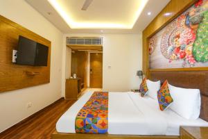 a hotel room with a bed and a flat screen tv at FabHotel Prime Star 17 - Nr Yashobhoomi Convention Centre in New Delhi +41 photos