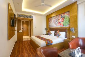 a hotel room with a bed and a table and chair at FabHotel Prime Star 17 - Nr Yashobhoomi Convention Centre in New Delhi