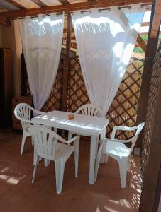 ein weißer Tisch und Stühle auf einer Terrasse in der Unterkunft Pinus Village, Pula, sud Sardegna casa vacanze Vera's House in Fort Village