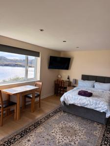 a bedroom with a bed and a table and a window at Loch Morar Private Suite in Mallaig
