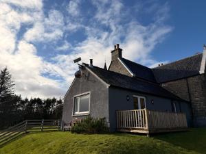 a house with a deck on the side of it at Loch Morar Private Suite in Mallaig