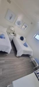 a bedroom with two beds and pictures on the wall at 2 x Bedroom Deluxe Hampton Apartment in Shoal Bay