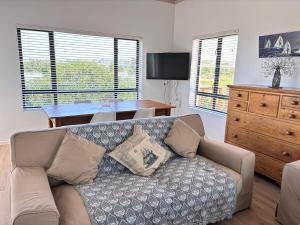 Una sala de estar con un sofá y una mesa de madera. en 120 on Lyme, en St Francis Bay
