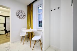 a dining room with a table and a clock on the wall at Apartament Wroclawska SELF CHECK-IN 24H in Bytom +4 photos