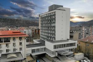 a tall white building in a city with buildings at Balkan Tower Deluxe Ultra in Gabrovo