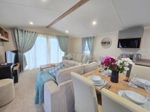 a living room with a couch and a table at Cornwall Caravan Retreat 3 Crantock in Crantock